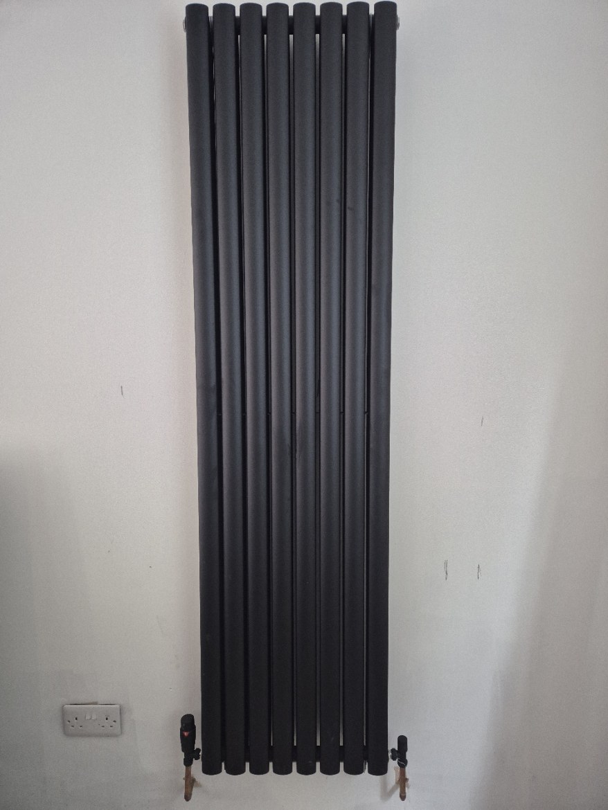 Tall black column radiator installation